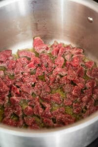 searing pieces of meat in pan