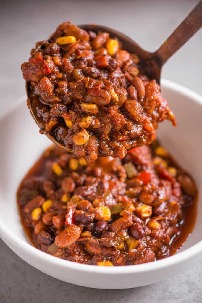 scooping homemade vegan chili into a bowl