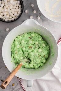 Folding whipped cream into watergate salad mixture.