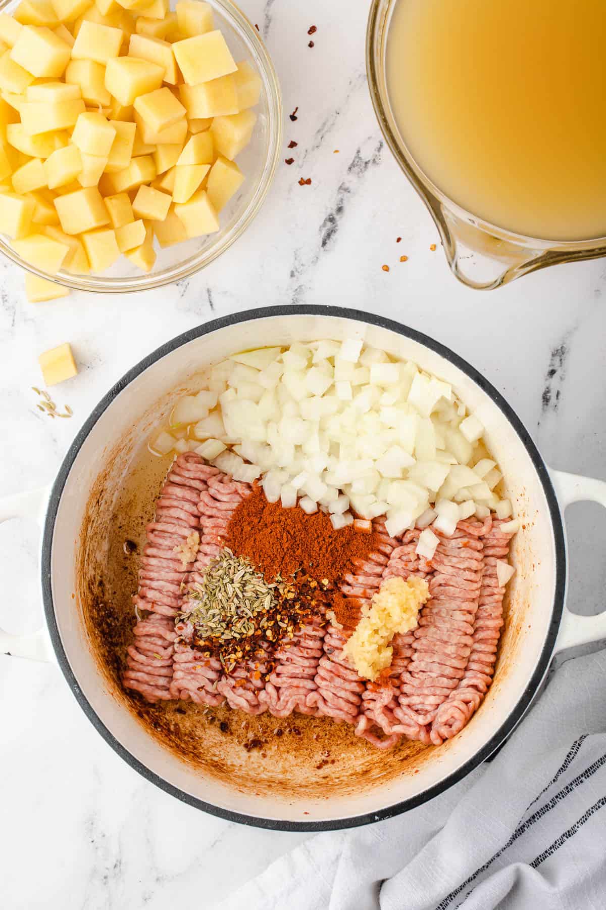 ground pork and onions in pot for soup